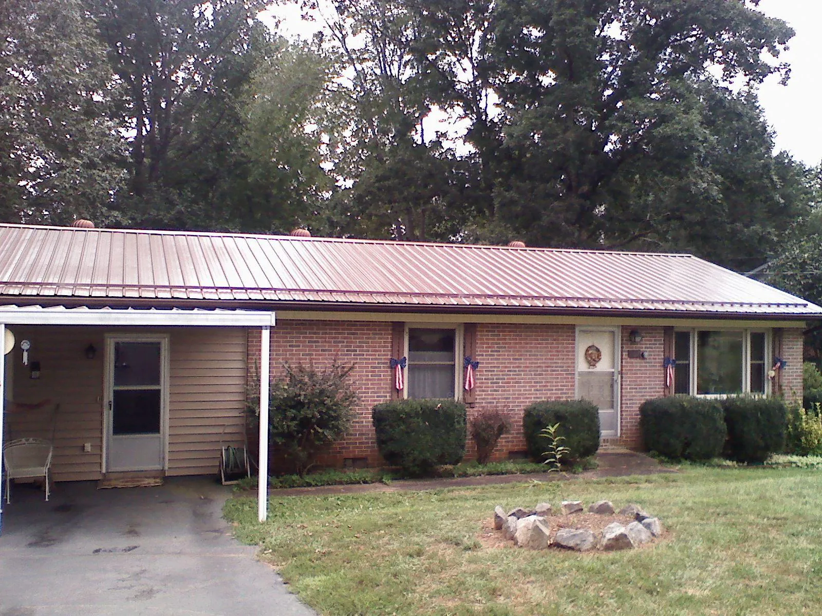 Bronze metal roof and carport on a brick ranch home — Roof Repair work by our crew in Elberton